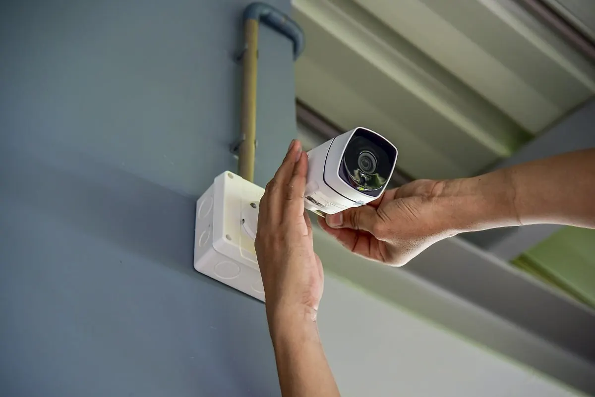 Technician mounting a CCTV camera on a wall